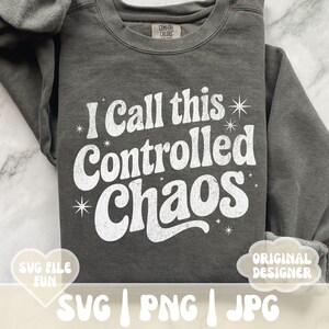 May include: Dark gray sweatshirt with the text "I Call this Controlled Chaos" in white, retro-style font. The sweatshirt has a crew neck and long sleeves. The image also includes the text "SVG FILE FUN" and "ORIGINAL DESIGNER".