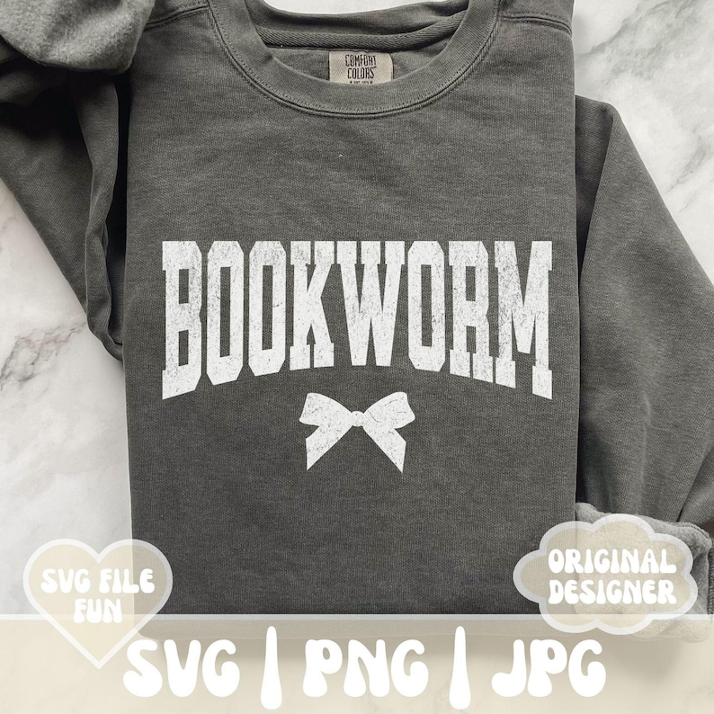 May include: A gray sweatshirt with the text "BOOKWORM" in white letters. A white bow is centered below the text. The sweatshirt is a comfortable, casual style.