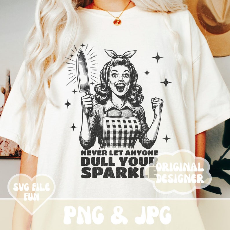 Puede incluir: Una camiseta blanca con una ilustraci&oacute;n en blanco y negro de una mujer sosteniendo un cuchillo. El texto "Never let anyone dull your sparkle" est&aacute; impreso en la camiseta.