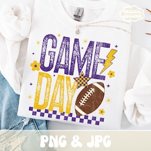 Puede incluir: Sudadera blanca con un gr&aacute;fico "GAME DAY" en morado y amarillo, con un bal&oacute;n de f&uacute;tbol americano, estrellas y un rayo. El dise&ntilde;o incluye un borde a cuadros y detalles florales. Las palabras "PNG & JPG" est&aacute;n en la parte inferior.