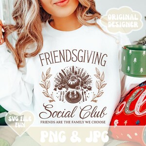 May include: White Friendsgiving Social Club sweatshirt with a brown graphic design. The design includes the text "FRIENDSGIVING Social Club" with a Thanksgiving-themed illustration. The phrase "FRIENDS ARE THE FAMILY WE CHOOSE" is also included.