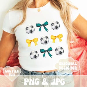 May include: A white t-shirt with a design of soccer balls and bows. The bows are in yellow and green. The text "Original Designer" is on the shirt.