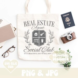 K&ouml;nnte beinhalten: Eine wei&szlig;e Einkaufstasche mit einem schwarzen und grauen Design, auf dem "Real Estate Agent Social Club It's a beautiful day to sell houses" steht. Das Design beinhaltet ein Haus, einen Schl&uuml;ssel, eine Kaffeetasse und ein Schild mit der Aufschrift "Verkauft".