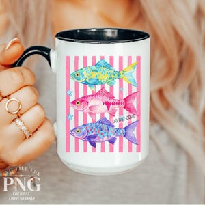May include: White ceramic mug with a black handle and rim, featuring three colorful fish illustrations on a pink striped background. The fish are blue, pink, and yellow, with the text "DO NOT COPY" visible.