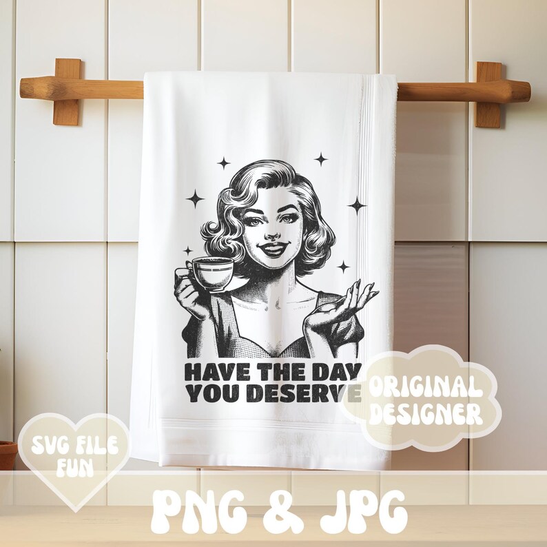 Puede incluir: Toalla de cocina blanca con una ilustraci&oacute;n retro en blanco y negro de una mujer sosteniendo una taza de t&eacute;. El texto "HAVE THE DAY YOU DESERVE" est&aacute; impreso debajo de la imagen. La toalla est&aacute; colgada de un toallero de madera.