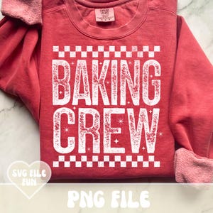 May include: A red sweatshirt with the words "BAKING CREW" in large white letters. The text is framed by a checkered pattern. The sleeves are cuffed, and the shirt has a crew neck. The words "SVG FILE FUN" and "PNG FILE" are also visible.