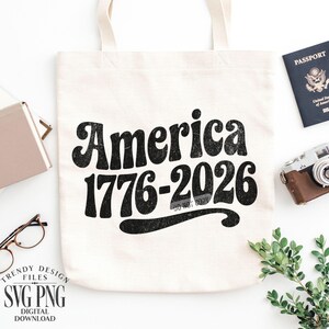 May include: Cream-colored tote bag with the words "America 1776-2026" in a retro font. The bag is surrounded by a passport, a vintage camera, glasses, and a small plant. The design is a digital download.
