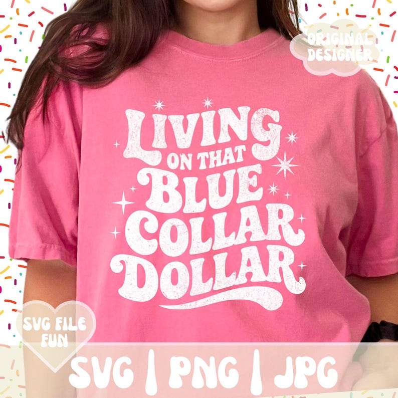 May include: A pink t-shirt with the text "Living on that Blue Collar Dollar" in a retro font. The shirt also has the text "SVG File Fun" and "Original Designer". The shirt is a casual style.