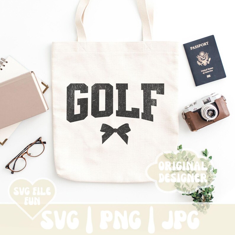 May include: A white tote bag with the word "GOLF" printed in black with a distressed look. A black bow is below the word. The bag is on a white surface with a passport, camera, and greenery.