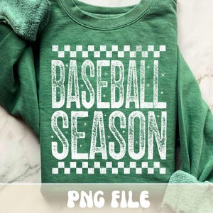K&ouml;nnte beinhalten: Gr&uuml;nes Sweatshirt mit dem Text "BASEBALL SEASON" in wei&szlig;en, abgenutzten Buchstaben, umrahmt von einem schwarz-wei&szlig;en Schachbrettmuster. Die Worte "PNG FILE" stehen am unteren Rand des Sweatshirts.