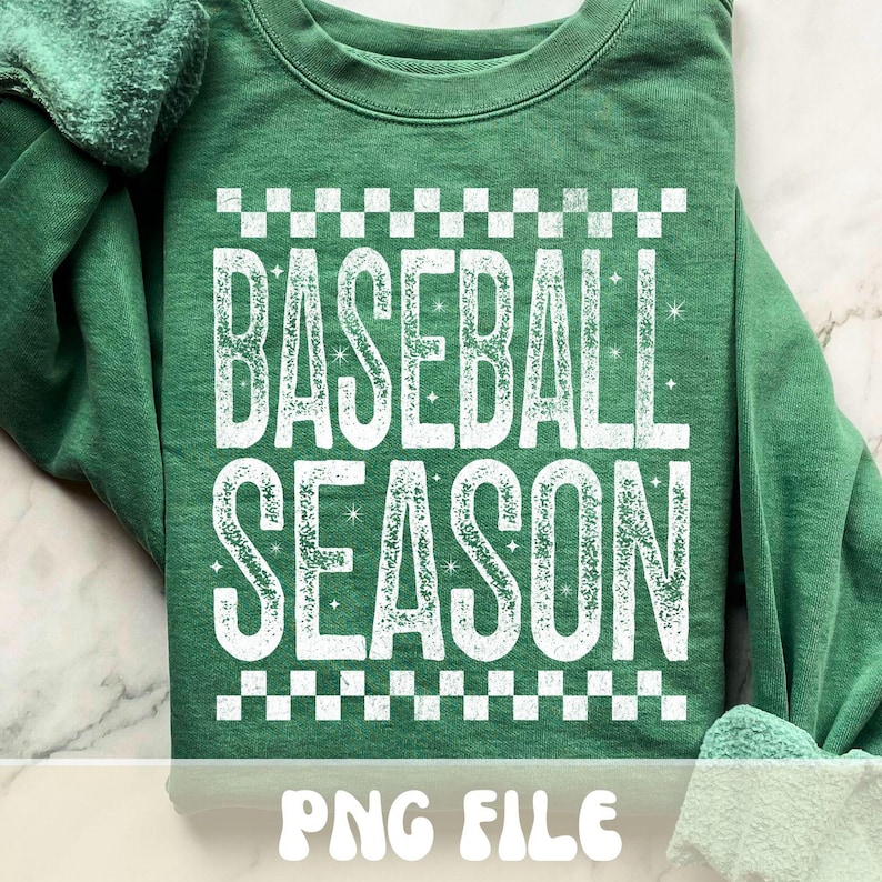 K&ouml;nnte beinhalten: Gr&uuml;nes Sweatshirt mit dem Text "BASEBALL SEASON" in wei&szlig;en, abgenutzten Buchstaben, umrahmt von einem schwarz-wei&szlig;en Schachbrettmuster. Die Worte "PNG FILE" stehen am unteren Rand des Sweatshirts.
