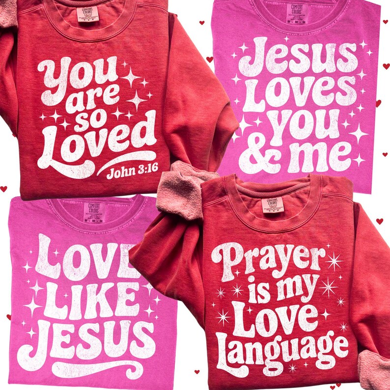 Op de afbeelding: Vier shirts met lange mouwen in rood- en roze tinten. Elk shirt toont witte tekst met zinnen als "You are so Loved" en "Jesus Loves You & Me". De shirts hebben een vintage, retro stijl.