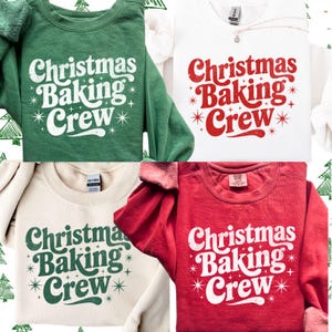 Könnte beinhalten: Vier Sweatshirts in Grün, Weiß, Beige und Rot, jeweils mit dem Text "Christmas Baking Crew" in einem Retro-Schriftstil und Sternen. Der Text ist weiß oder grün. Ein festliches, saisonales Thema.