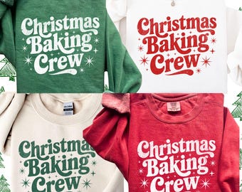 May include: Four sweatshirts in green, white, beige, and red, each with the text "Christmas Baking Crew" in a retro font. The text is in white or green, with star accents. The sweatshirts are crew neck style.