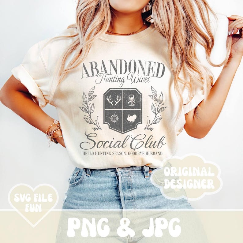 Może przedstawiać: Biała koszulka z grafiką w stylu vintage, na kt&oacute;rej widnieje napis "Abandoned Hunting Wives Social Club. Hello Hunting Season, Goodbye Husband."