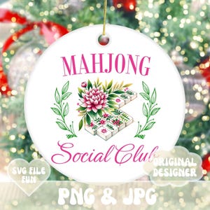 Puede incluir: Un adorno navide&ntilde;o redondo blanco con un dise&ntilde;o floral rosa y el texto "Mahjong Social Club".