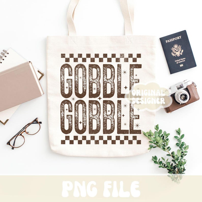 Może przedstawiać: Kremowa torba typu tote z brązowymi literami "GOBBLE GOBBLE". Obraz zawiera paszport, aparat fotograficzny w stylu vintage, notatnik, okulary i zieleń. Słowa "PNG FILE" znajdują się na dole.