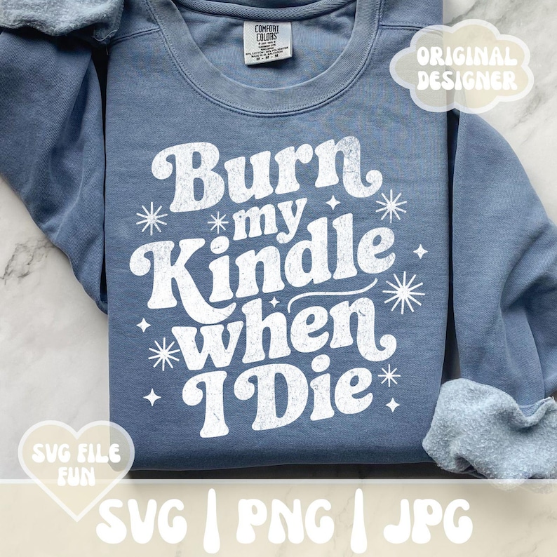 May include: A blue Comfort Colors sweatshirt with the text "Burn my Kindle when I Die" in white, along with star and sparkle graphics. The design includes the words "SVG FILE FUN" and "ORIGINAL DESIGNER".