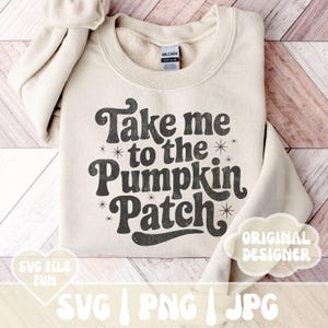 May include: Cream-colored sweatshirt with the text "Take me to the Pumpkin Patch" in a retro font. The design includes star accents. The sweatshirt is folded, with the sleeves visible. The brand tag is visible.