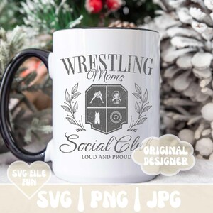May include: White ceramic coffee mug with a black handle. The mug has a black rim and a design that says "Wrestling Moms Social Club Loud and Proud" with a crest featuring a wrestler, a weight, and a wine glass.