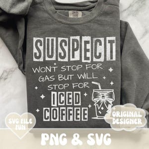 Op de afbeelding: Een grijs sweatshirt met witte tekst die "SUSPECT WON'T STOP FOR GAS BUT WILL STOP FOR ICED COFFEE" luidt. De tekst is in een bloklettertype en wordt omringd door kleine witte sterren. Rechts van de tekst is een afbeelding van een glas ijs koffie met een strik erop. Het sweatshirt wordt verkocht als digitaal download.