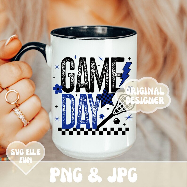 May include: White ceramic mug with a black handle and rim, featuring the words "GAME DAY" in black and blue, along with a lacrosse stick, star, and lightning bolt graphic. The mug also has the text "PNG & JPG".