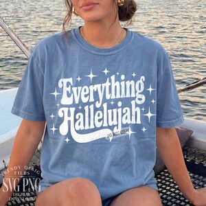 May include: A light blue t-shirt with the words "Everything Hallelujah" in white, stylized text. The shirt also features starburst graphics and the text "DO NOT COPY" at the bottom. The shirt is part of a digital design collection.
