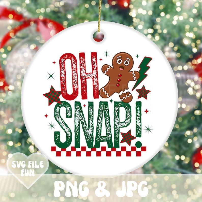 May include: A white ceramic Christmas ornament with the phrase "OH SNAP!" in red and green, along with a gingerbread man and star accents. The ornament has a gold string for hanging and is set against a blurred Christmas tree background.
