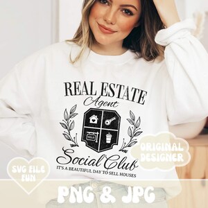 May include: White sweatshirt with a black graphic that reads "REAL ESTATE Agent Social Club". The design includes a house, key, coffee cup, and the word "SOLD". The text "IT'S A BEAUTIFUL DAY TO SELL HOUSES" is also included.