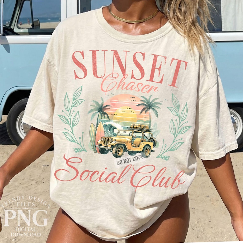 K&ouml;nnte beinhalten: Cremefarbenes T-Shirt mit einem Grafikdesign mit den Worten "Sunset Chaser Social Club". Das Design umfasst einen gelben Jeep, Palmen, ein Surfbrett und eine Sonnenuntergangsszene. Das Shirt hat kurze &Auml;rmel und eine lockere Passform.