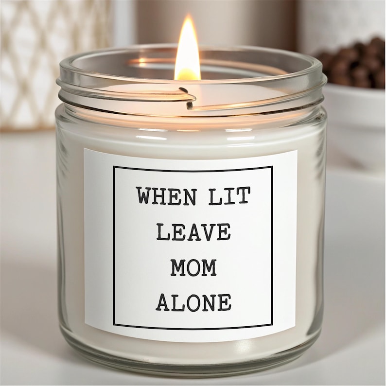 May include: A white candle in a clear glass jar with a white label that reads "WHEN LIT LEAVE MOM ALONE".