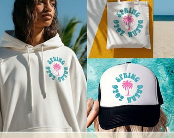 Op de afbeelding: Een witte hoodie, draagtas en truckerpet met een cirkelvormig ontwerp met een roze palmboom en de woorden "Spring Break 2026" in teal. De pet heeft een zwarte mesh achterkant.