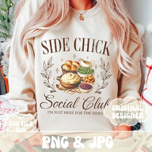 Może przedstawiać: Beżowa bluza z napisem "SIDE CHICK Social Club I'M JUST HERE FOR THE SIDES" w brązowych literach. Projekt zawiera kreskówkową ilustrację kolacji z okazji Święta Dziękczynienia z puree ziemniaczanym, zielonymi fasolkami, sosem żurawinowym i bułeczkami.