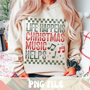 May include: A beige sweatshirt with the text "LIFE HAPPENS CHRISTMAS MUSIC HELPS" in red and green. The design includes musical notes and a checkered border, perfect for the holiday season. The sweatshirt is a PNG file.