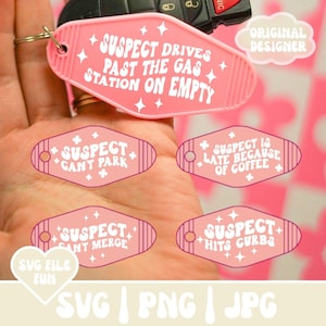 May include: Five pink motel keychains with white text. The keychains feature humorous driving-related phrases like "Suspect Drives Past the Gas Station on Empty" and "Suspect Can't Park".