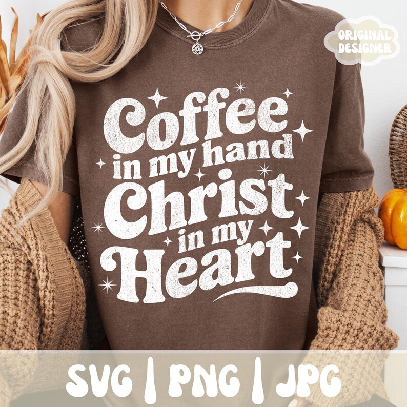 May include: A brown t-shirt with the text "Coffee in my hand Christ in my Heart" in a white, distressed font. The shirt also includes the text "SVG | PNG | JPG" at the bottom and "ORIGINAL DESIGNER" in the upper right corner.