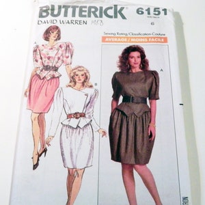 May include: Butterick 6151 sewing pattern envelope featuring David Warren designs. The cover displays illustrations and a photograph of dresses with puff sleeves, peplum waists, and belts. Text includes Butterick 6151, size 6, and Average/Moins Facile sewing rating.