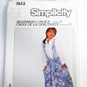 May include: Simplicity sewing pattern 7613. The pattern features a blue floral print dress with pockets and suspenders. The pattern is labeled "Beginner's Choice" and includes sizes 14 and Eur 42.