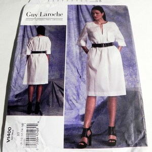 May include: A white dress pattern by Guy Laroche, featuring a knee-length dress with a black belt and short sleeves. The pattern includes a front pocket and a V-neckline. The pattern size is B5, fitting sizes 8-16.