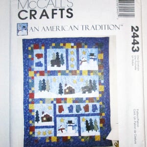 May include: A McCall's Crafts pattern envelope featuring a winter-themed quilt design. The quilt showcases snowmen, houses, trees, and mittens in a blue, red, and yellow color scheme. The text "AN AMERICAN TRADITION" is visible.