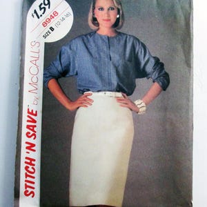 May include: A vintage McCall's sewing pattern cover featuring a woman wearing a blue long-sleeve top and a white pencil skirt. The pattern is labeled "STITCH 'N SAVE" and includes the size B (12-14-16).