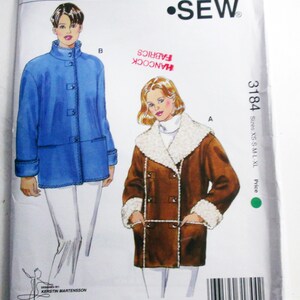May include: A Kwik Sew pattern envelope, pattern number 3184, featuring illustrations of two coats. One coat is blue with a mandarin collar, and the other is brown with a faux fur collar. The envelope includes the text "Misses Sizes: XS-S-M-L-XL".