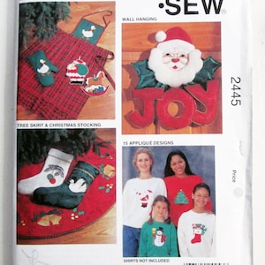 May include: Kwik Sew pattern 2445 for holiday sewing projects. The envelope features illustrations of an apron, pot holders, oven mitt, wall hanging, tree skirt, Christmas stockings, and 15 applique designs including Santa, a snowman, and trees.