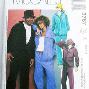 May include: McCall's 3787 sewing pattern envelope featuring illustrations of tracksuits. The designs include a black zip-up jacket and pants, a blue zip-up jacket and pants, a teal zip-up jacket and pants with a bucket hat, and a purple hooded jacket.