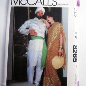 May include: A McCall's sewing pattern envelope 8265 for a medium size. The cover features an illustration of two individuals wearing traditional attire, including a white tunic with a green sash and a gold patterned sari, holding a handheld fan.