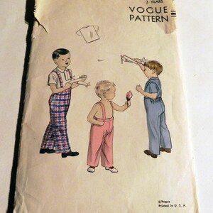 May include: Vintage Vogue Pattern envelope featuring illustrations of children. The cover shows three children, one in plaid overalls, one in pink overalls, and one in blue overalls, each holding a toy airplane or ice cream. The text reads "3 Years" and "Vogue Pattern".