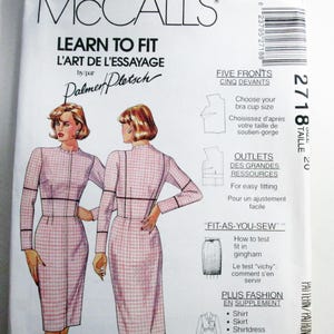 May include: A McCall's sewing pattern envelope, number 2718, size 20, titled Learn to Fit. The front displays illustrations of a dress in a pink and white gingham check pattern, featuring long sleeves, a high neckline, and a fitted silhouette.