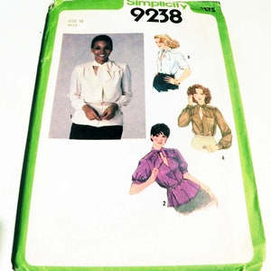 May include: Simplicity sewing pattern 9238, size 10 Miss. The pattern features illustrations of blouses with various styles, including a white blouse with a bow, a white blouse with a collar, a purple blouse, and a brown blouse.