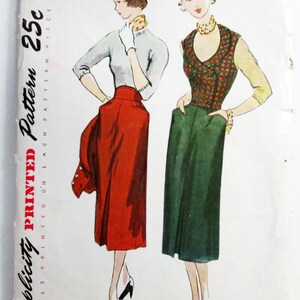 May include: A vintage Simplicity sewing pattern envelope, number 3299, size 14, bust 32. The illustration shows two outfits: one with a light gray top and red skirt, the other with a green and red plaid vest over a green skirt and yellow sleeves.