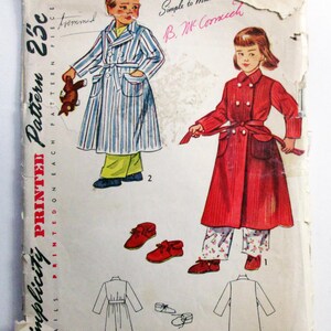 May include: Vintage Simplicity pattern for children's clothing, size 2. The illustration shows a child in a striped robe and another in a red coat. Includes drawings of the garments and shoes. The text reads "Simple to Make".
